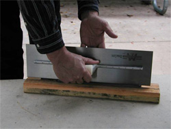 A cement mason shows off his trowel once it has been sharpened